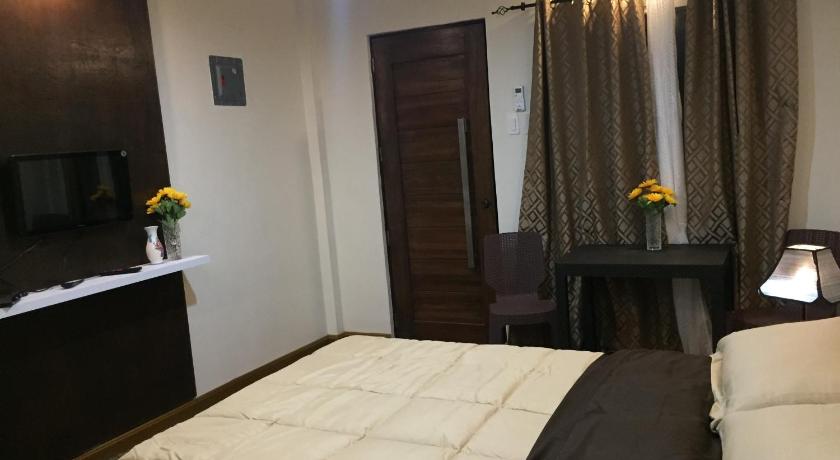 a bedroom with a bed and a dresser, Mirasol Residences in Daet