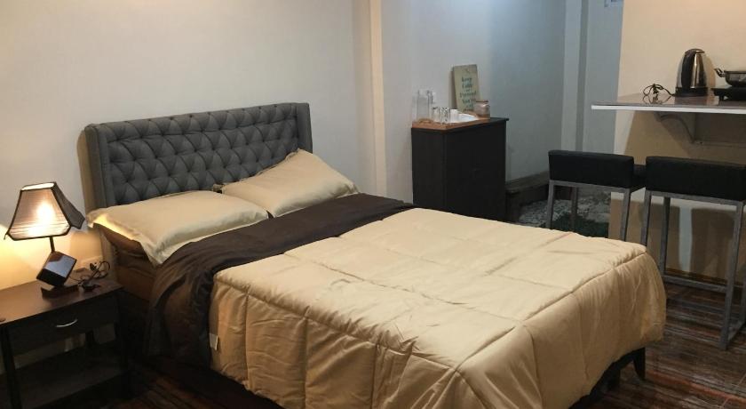 a hotel room with a bed and a desk, Mirasol Residences in Daet