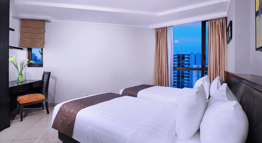 a bed room with a white bedspread and pillows, Horison Suites & Residence Rasuna Jakarta in Jakarta