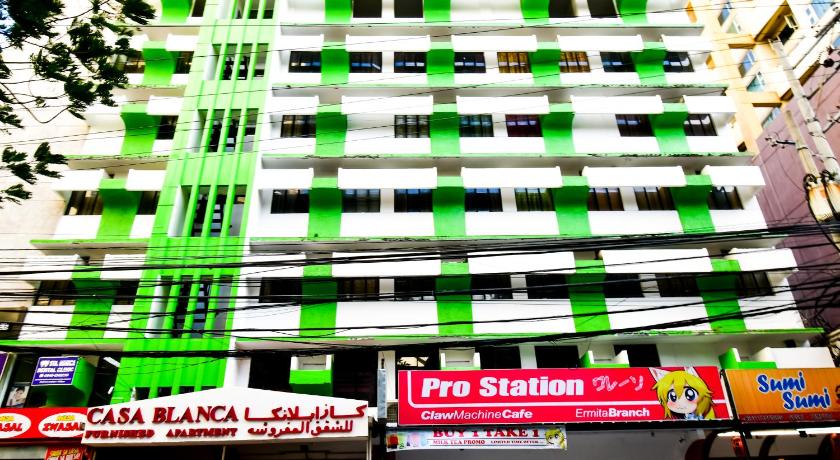 a tall building with a bunch of signs on it, Casa Blanca Apartment in Manila