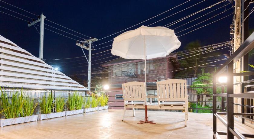 a white umbrella sitting on top of a wooden bench, Baan Pak Hadd Jao Sea Wind2 in Phetchaburi