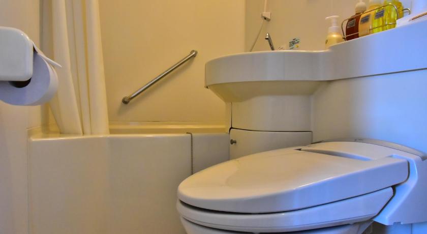 a white toilet sitting in a bathroom next to a sink, Hasebe Machiya Inn in Tokyo