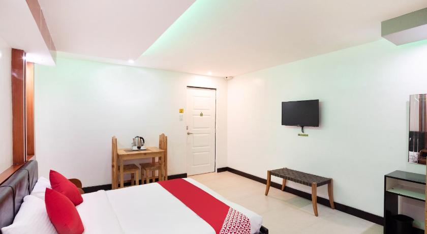 a hotel room with a bed, chair, and nightstand, OYO 195 Ranchotel - BiÃ±an in Binan