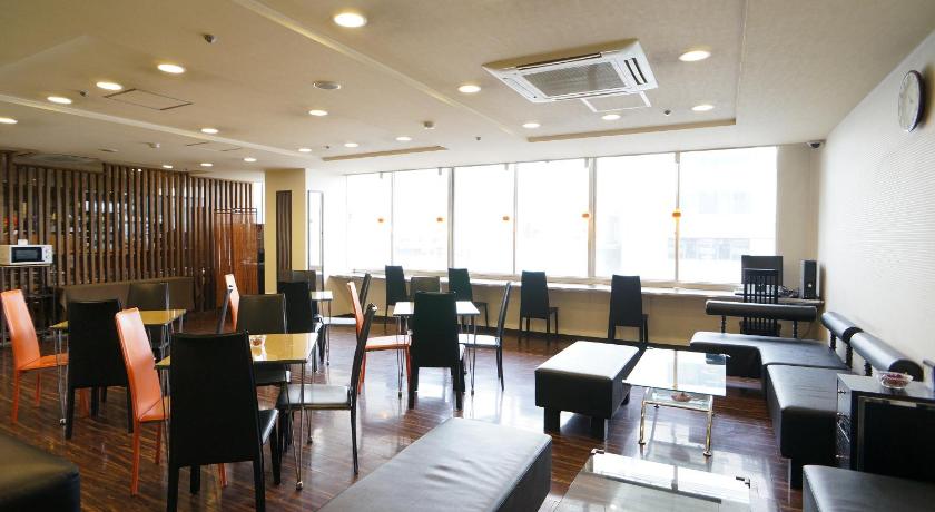 a living room filled with furniture and a large window, Green Rich Hotel Kagoshima Tenmonkan in Kagoshima