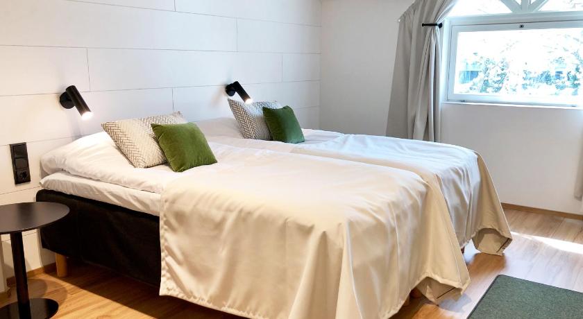 a bed room with a white bedspread and pillows, HeseHotelli Turku Kaskentie in Turku