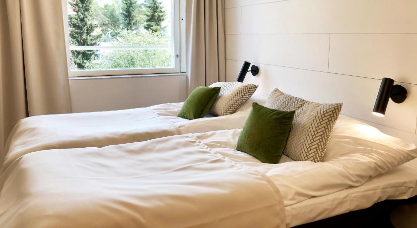 a bed with a white comforter and pillows, HeseHotelli Turku Kaskentie in Turku