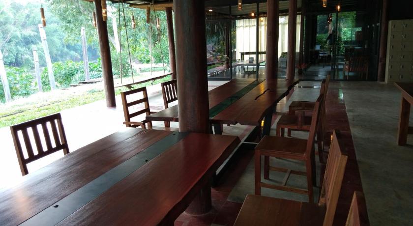 a wooden dining room with wooden tables and chairs, Boutique Raft Resort River Kwai in Kanchanaburi