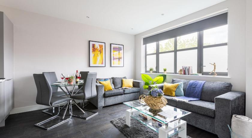 a living room filled with furniture and a large window, homely - Watford Premier Apartments (Warner Bros Studio) in London