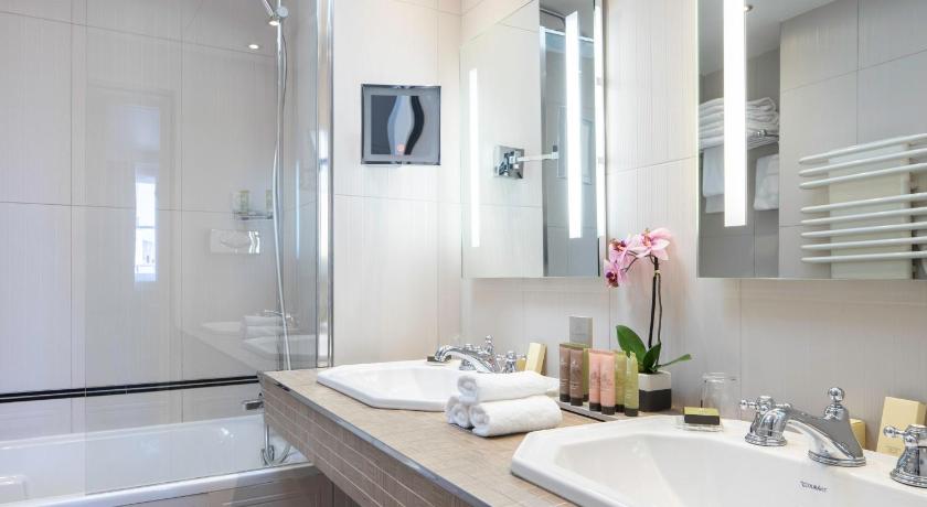 a bathroom with a sink, mirror, and bathtub, Bradford Elysees - Astotel in Paris