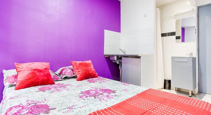 a bedroom with a red bedspread and pink walls, Hotel Monte-Cristo in Marseille