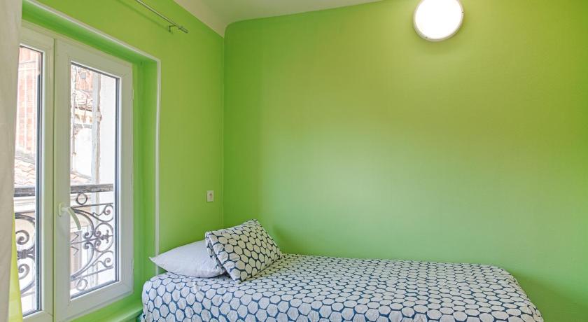 a green and white bedroom with a blue wall, Hotel Monte-Cristo in Marseille