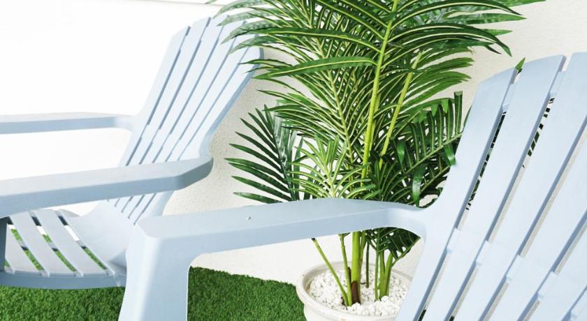 a green lawn chair sitting in front of a green plant, Ocean Views 3 in Newquay