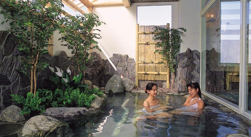 two people are relaxing in a pool of water, Hotel Yuzawa Yuzawa Denkiya in Yuzawa