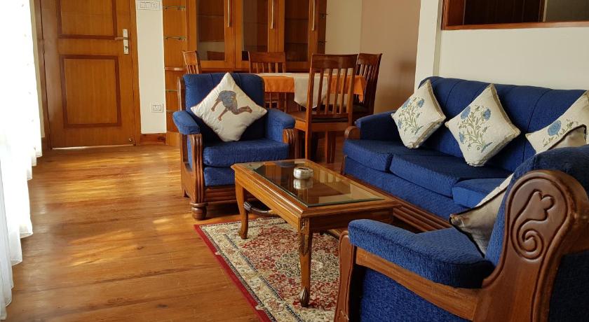 a living room filled with furniture and a blue couch, Woodland Hill Stay in Shillong