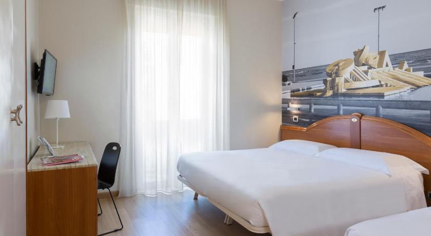 a bedroom with a bed and a dresser, B&B Hotel Pescara in Pescara