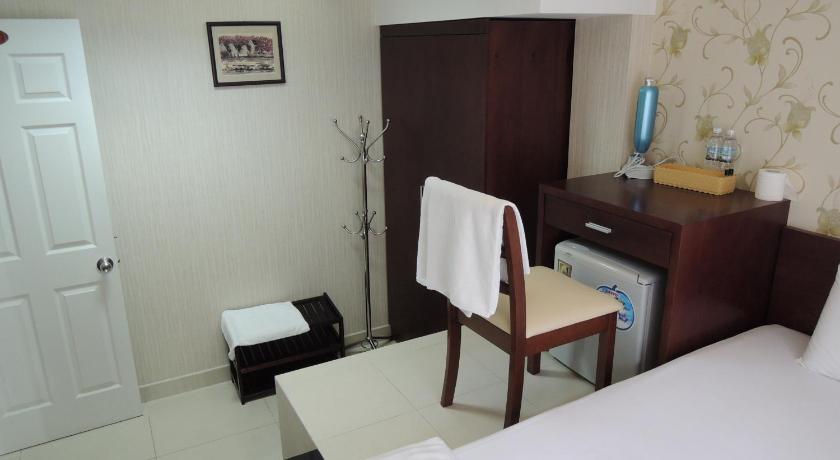 a hotel room with a bed, chair, desk and a mirror, Alupoint Hotel in Ho Chi Minh City