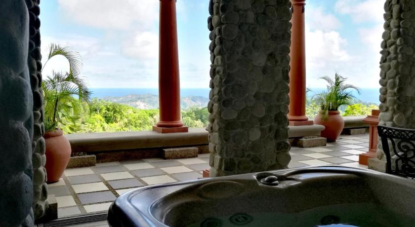 a bathroom with a fountain and a large tub, Hotel Villa Caletas in Herradura