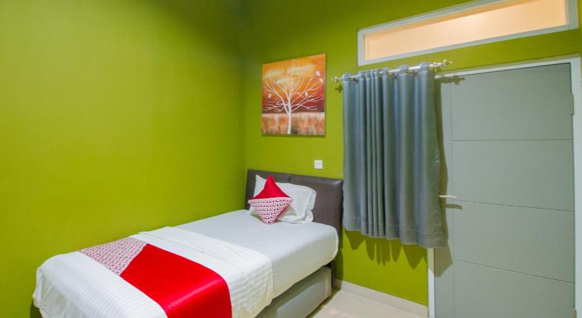 a room with a bed, a desk and a painting on the wall, OYO 871 Aira Costel in Puncak