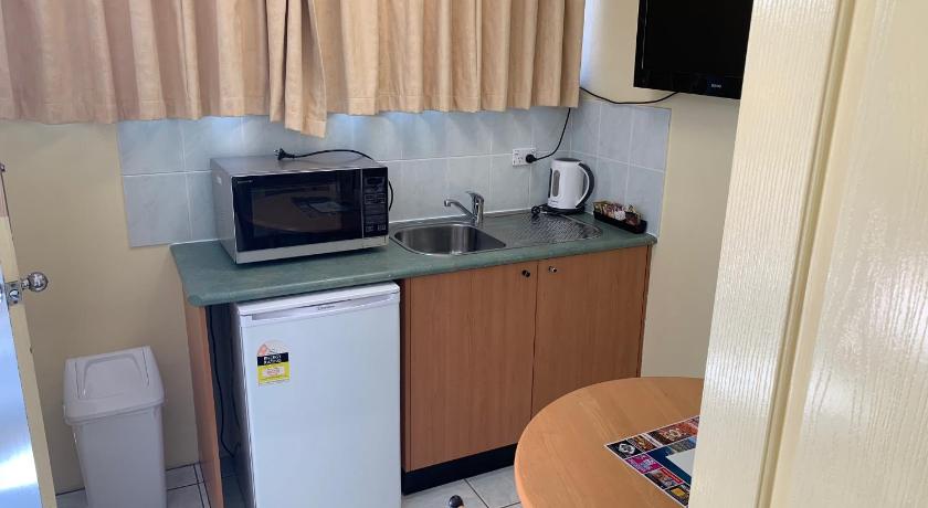 a kitchen with a microwave and a sink, John Oxley Motel in Port Macquarie
