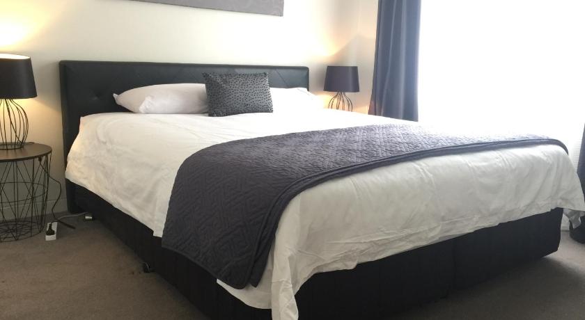 a hotel room with a bed and two lamps, Cronulla Beach Break in Sydney