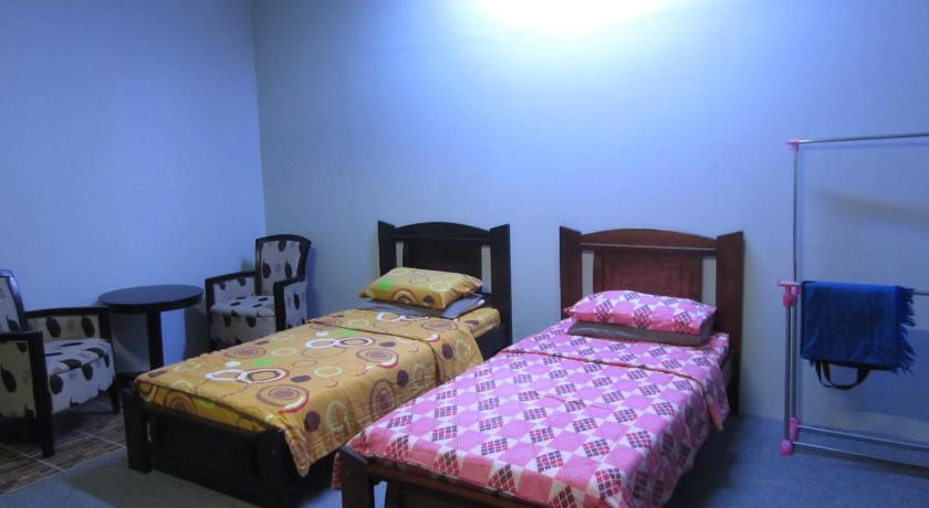 two beds in a room with a blue wall, Happy Owl in Simpang Pulai
