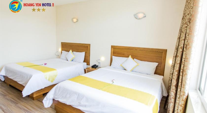 two beds in a room with a white bedspread, Hoang Yen Hotel 2 in Quy Nhon (Binh Dinh)
