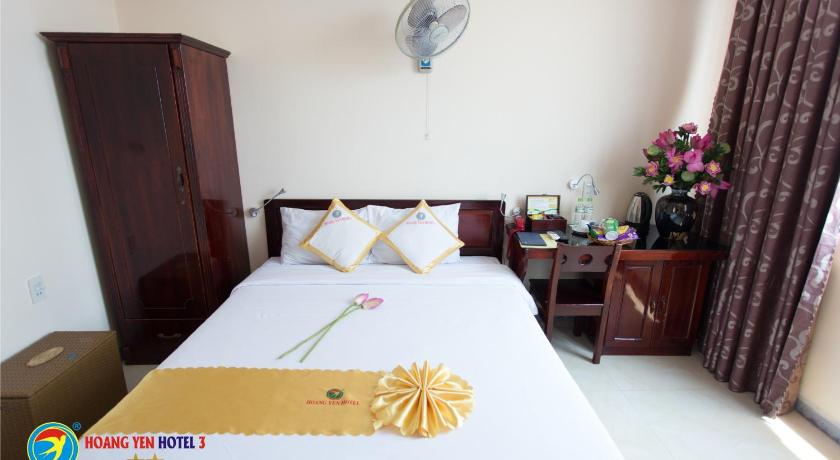 a bed room with a white bedspread and a white table, Hoang Yen Hotel 3 in Quy Nhon (Binh Dinh)