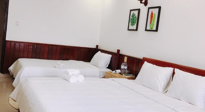 a bedroom with a white bedspread and white pillows, VIET Hostel in Hue