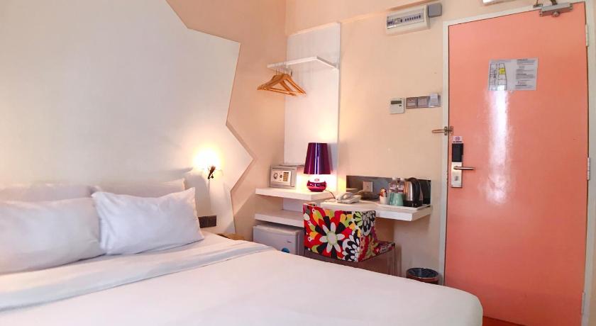 a bedroom with a white bed and white walls, Melange Hotel Bukit Bintang in Kuala Lumpur