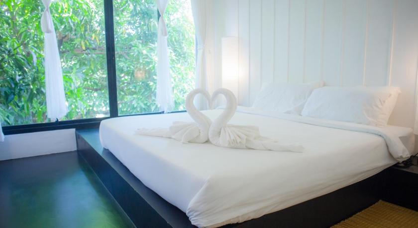 a white cat sitting on top of a white bed, Trat 101 Hotel (SHA Certified) in Trat
