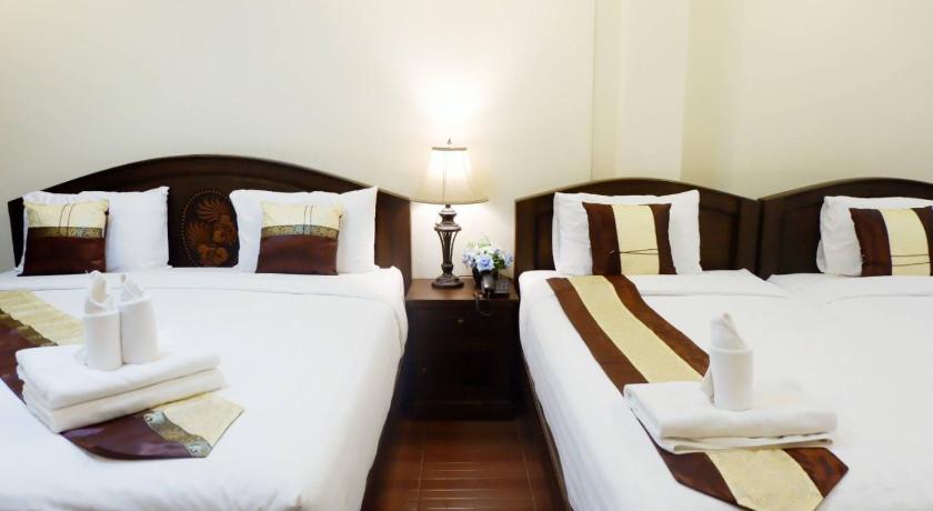 a hotel room with two beds and two lamps, nanbaankhun hotel in Nan