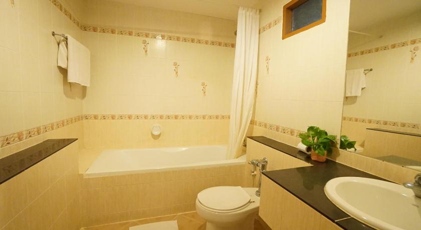 a white toilet sitting next to a bath tub, The Country Lake View Hotel in Suphan Buri
