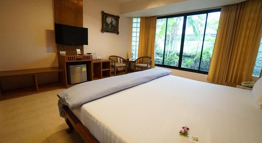 a hotel room with a bed and a television, The Country Lake View Hotel in Suphan Buri