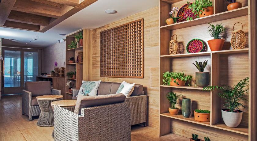a living room filled with furniture and plants, Windsor California Copacabana in Rio De Janeiro
