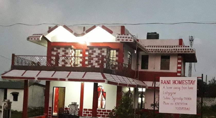 a man standing in front of a red and white building, Rani Homestay in Cherrapunji