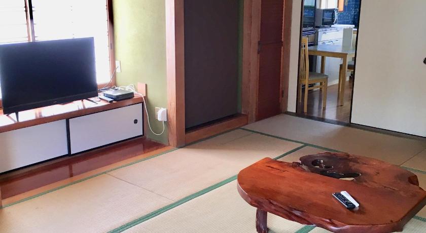 a wooden chair sitting on top of a wooden floor next to a tv, まるで一国一城の主 佐藤邸 in Nichinan