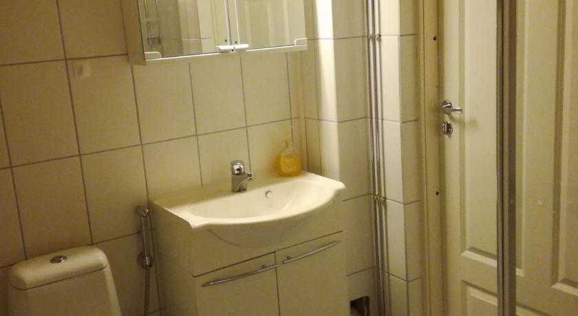 a bathroom with a toilet and a sink, Guesthouse Lokinlaulu in Kotka