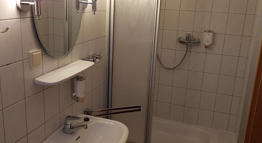 a bathroom with a shower, sink, and mirror, Hotel Landgut Ochsenkopf in Kemberg