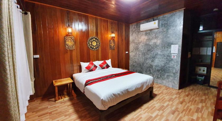 a hotel room with a bed and a dresser, The Nature in Sukhothai