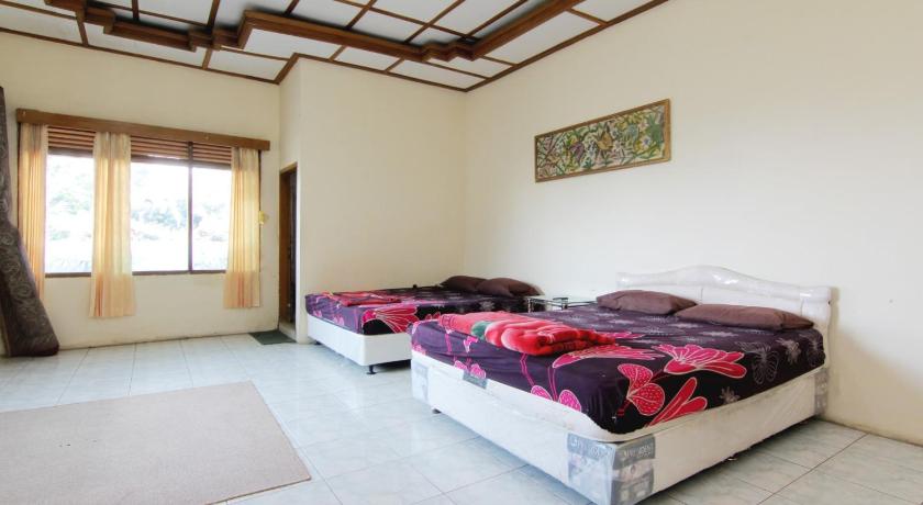 a bedroom with a bed and a window, Villa Penginapan Purnama in Bandung