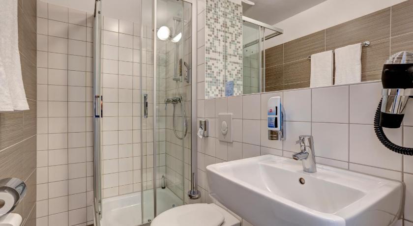 a white toilet sitting next to a sink in a bathroom, MEININGER Hotel Hamburg City Center in Hamburg