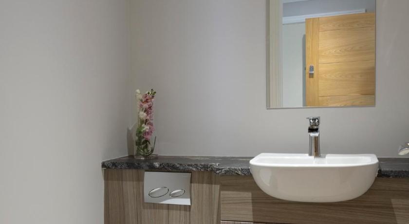 a bathroom with a sink, toilet and bathtub, Hampden Apartments - The Archie in London