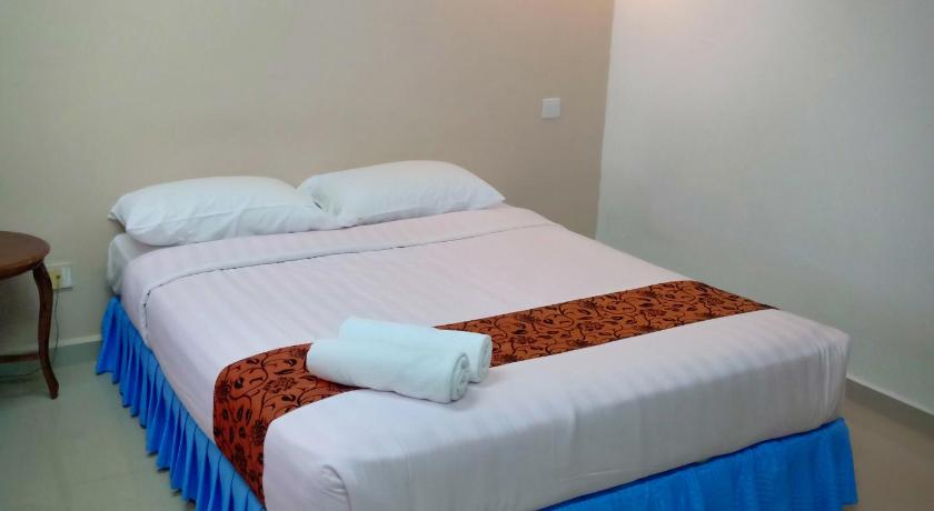 two beds in a room with a white bedspread, Hotel K.T. Mutiara in Kuala Terengganu