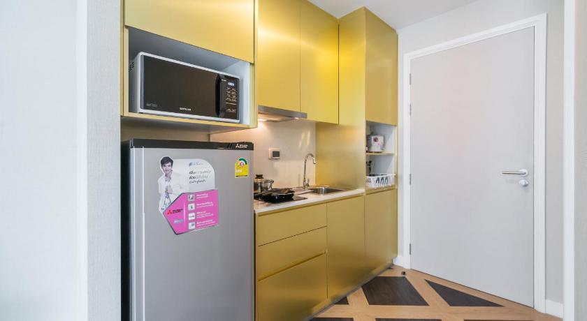 a kitchen with a microwave and a refrigerator, ESPANA Resort Condo at Jomtien in Pattaya