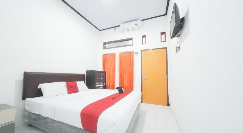 a hotel room with a bed and a television, RedDoorz Syariah near Mall Roxy Banyuwangi 2 in Banyuwangi