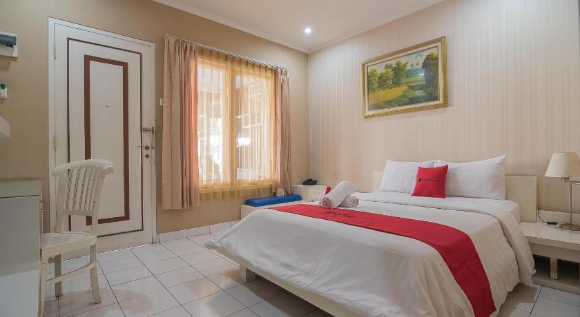 a hotel room with a bed, chair, and nightstand, RedDoorz near Setrasari Mall 2 in Bandung