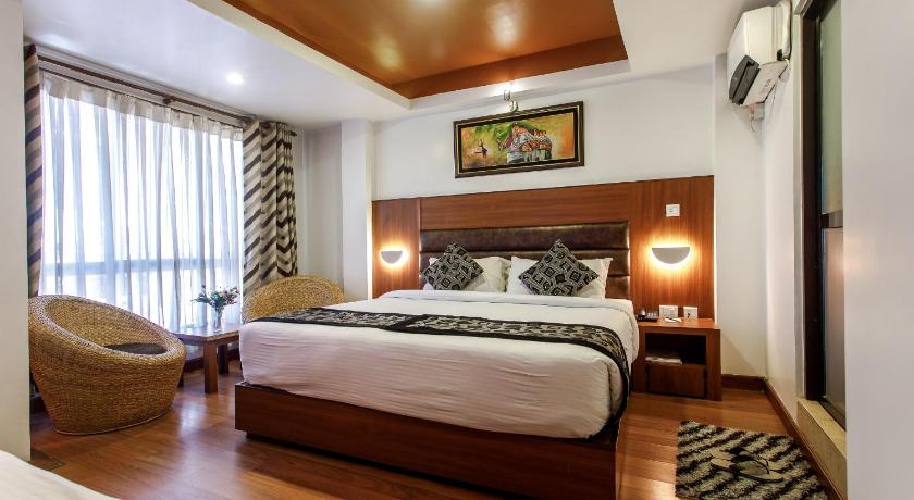 a bedroom with a large bed and a large window, Hotel Shreesu in Kathmandu