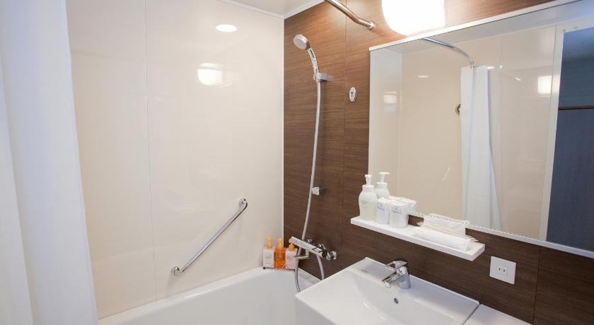 a bathroom with a shower, sink, and mirror, Hotel Mielparque Yokohama in Yokohama