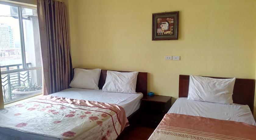 a hotel room with two beds and two windows, Hai Duong Hotel in Hoa Binh