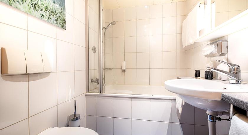 a bathroom with a sink, toilet and bathtub, Leonardo Boutique Hotel Rigihof Zurich in Zürich